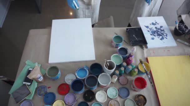 L'artiste prépare un tableau. Peinture blanche. Des gens dans des tabliers. Studio d'art. Bouteille de pulvérisation — Video