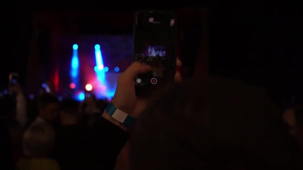 Onherkenbare handen silhouet nemen foto of opname video van live muziek concert met smartphone schieten podium lichten — Stockvideo