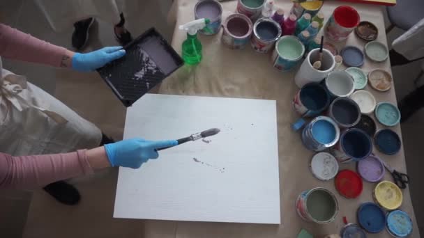 Ο καλλιτέχνης ζωγραφίζει μια αφηρημένη εικόνα. Άνθρωποι με ποδιές. . Μπογιές και βούρτσες. Πιτσιλιές χρωμάτων — Αρχείο Βίντεο