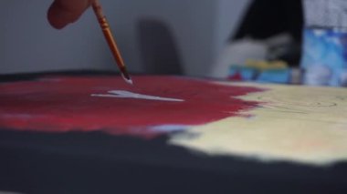 Erkek el fırçayla harfler çizer. Renkli arka plan. Sanat Stüdyosu. İşbirliği. Eş çalışma