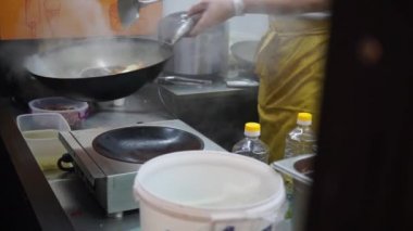 Şef, Wok Caddesi 'nde kızarmış sebze pişiriyor. Et Festivali. Geleneksel Asya Sıcak Yağ Gecesi Etleri.