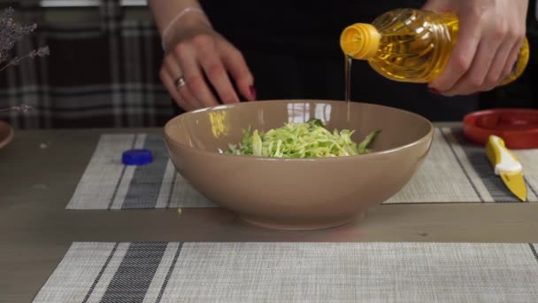 Jeune femme cuisiner dans la cuisine faire le dîner déjeuner préparer le repas salade laitue à l'huile de tournesol, lavande, un verre de vin, à travers une fenêtre une maison privée — Video