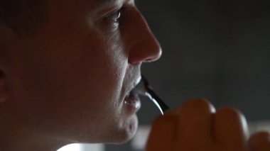 Banyoda aynanın önünde diş fırçalayan genç adam. Aynaya bakarak hijyen rutini yapıyorum. Sabah diş bakımı..