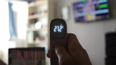 Beyaz kızılötesi lazer termometresi oda sıcaklığını ölçüyor. LCD göstergesi 27 derece santigrat derece gösteriyor. Temas olmayan dijital pirometre termal yalıtım eksikliği gösteriyor