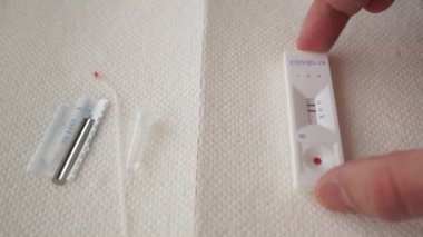 Bir el peçeteye hızlı bir koronavirüs testi uygular. Test sonuçları pozitif. COVID-19. Kan testi malzemeleri. Yakın plan. iki şerit