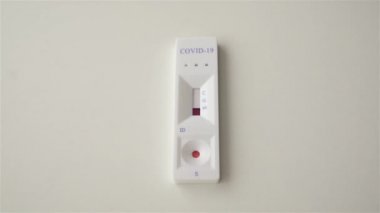 Kan testi yapılıyor. Beyaz arka planda hızlı koronavirüs testi. Test sonuçları pozitif. İki şerit. COVID-19. Kan testi malzemeleri. Yakın plan.