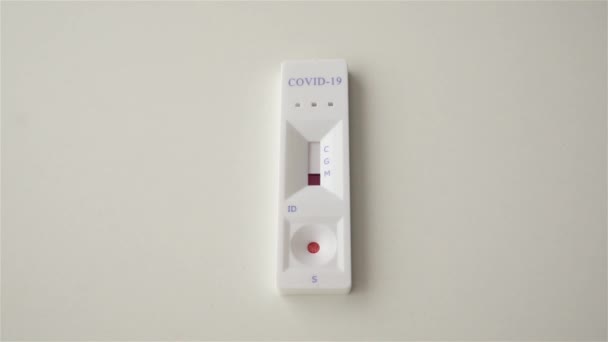 Blutprobenentnahme. Coronavirus-Schnelltest auf weißem Hintergrund. Das Testergebnis ist positiv. zwei Streifen. COVID-19. Bluttestvorräte. Nahaufnahme — Stockvideo