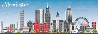 Gri binalar ve mavi gökyüzü ile Manchester manzarası.
