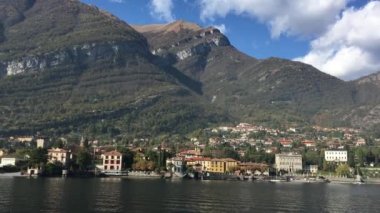 Lake Como, İtalya - 27 Ekim 2017: şehir ve arka planda İtalyan Alpleri ile Como Gölü kıyısında.