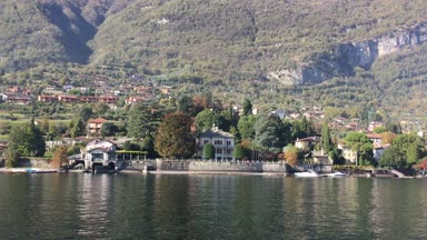 Lake Como, İtalya - 27 Ekim 2017: şehir ve arka planda İtalyan Alpleri ile Como Gölü kıyısında.