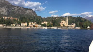 Lake Como, İtalya - 27 Ekim 2017: şehir ve arka planda İtalyan Alpleri ile Como Gölü kıyısında.