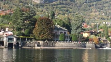 Lake Como, İtalya - 27 Ekim 2017: şehir ve arka planda İtalyan Alpleri ile Como Gölü kıyısında.