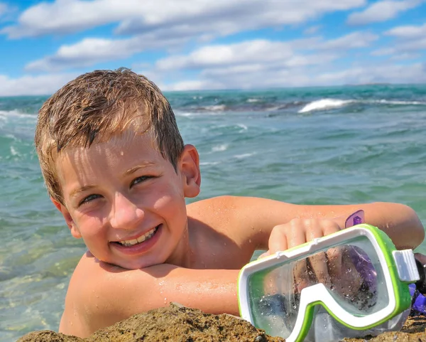 Smiling Young swimmer on the background of the sea put his hand with mask for diving — Stock Photo, Image