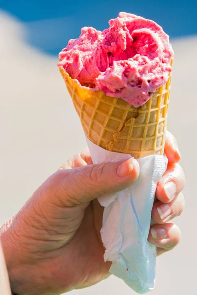 Fruit ice cream in hand in a waffle cup against the sky — Stock Photo, Image