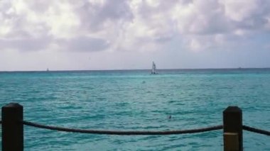 Boat sailing along the horizon against a blue sky under the white clouds of the Caribbean