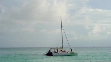 Tourists travel on a catamaran along the coast of the Caribbean