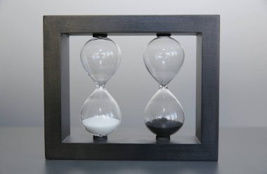 Gri arka planda ahşap bir çerçevede kum saati. Zaman kavramı.