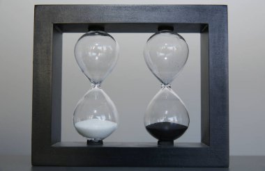 Gri arka planda ahşap bir çerçevede kum saati. Zaman kavramı.