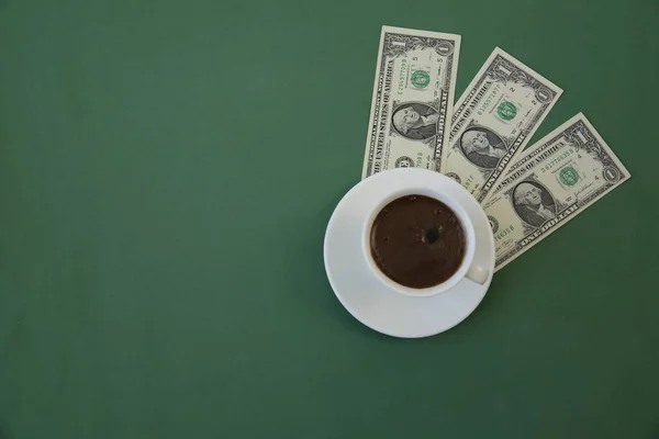cup of coffee on a green background with dollar bills. Three dollars. Coffee concept. Menu, background.