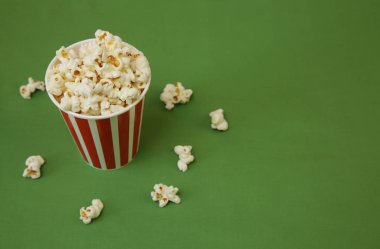 Yeşil arka planda kağıt bardakta patlamış mısır. Mesaj ve görüntü için yer var. Düz Yat, Top View. Geçmişi, kalıbı, kartı. Sinema kavramı.