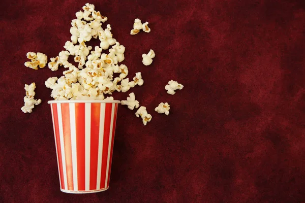 Palomitas Maíz Una Taza Papel Palomitas Maíz Esparcidas Sobre Fondo —  Fotos de Stock