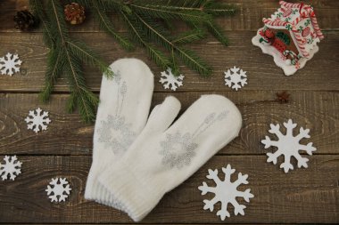Beyaz yün eldivenler, köknar dalı ve zencefilli ekmek, tahta zemin üzerinde kar tanesi. Noel arkaplanı, kompozisyon, kart.