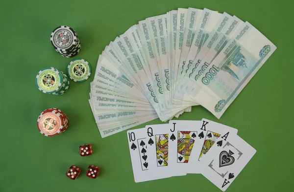 playing cards in a combination of Flash Royal and poker chips on a green background. Texas Hold\'em Poker. Gambling, business and finance. Flat lay. Top view.