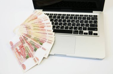 Beyaz arka planda klavyesinde Rusça beş bin dolar olan gümüş dizüstü bilgisayar. İş ve Finans. İnternetten alışveriş. Üst görünüm.