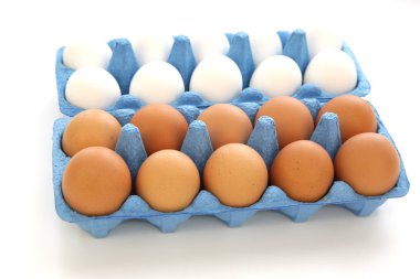 Beyaz arka planda izole edilmiş mavi karton kutulardaki organik çiftçi beyaz ve kahverengi tavuk yumurtaları. Paskalya ve tarım ürünleri.