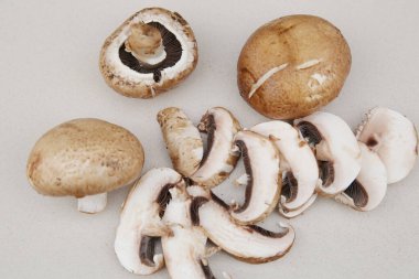 Yakın plan taze organik kahverengi mantar şampiyonu ve beyaz kesim tahtasında mantar dilimi. Düz yatış, üst görünüm.