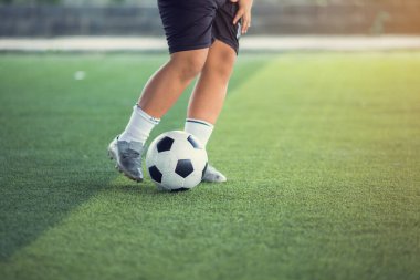 Erkek futbolcu yeşil suni sahada top atıyor. B
