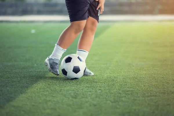 Erkek futbolcu yeşil suni sahada top atıyor. B