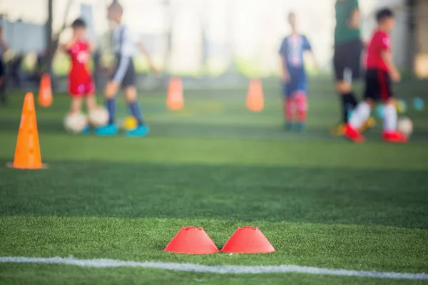 Selective focus to red marker cones are soccer training equipmen