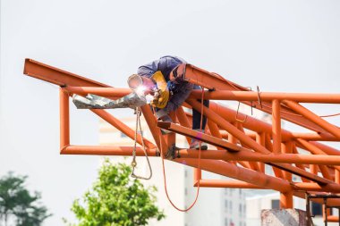 İnşaat alanındaki kaynakçılar. İşçi çeliği kaynaklıyor. 