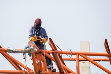 İnşaat alanındaki kaynakçılar. İşçi çeliği kaynaklıyor. 