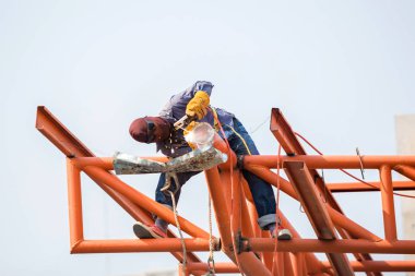 İnşaat alanındaki kaynakçılar. İşçi çeliği kaynaklıyor. 