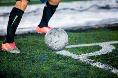 Futbolcu topu futbol sahasının köşesinde atıyor. Futbol ya da futbol akademisi.