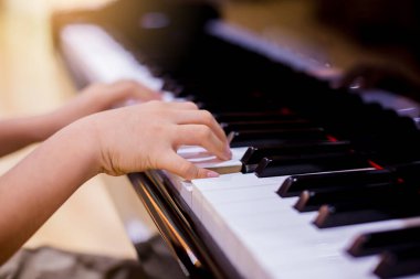 Piyano çalmak için çocuk parmaklarına ve piyano tuşuna özen göster. Konser için müzik aleti ya da öğrenme müziği var. Sahnede piyano çalan çocuk müzisyenin eli kapalı.