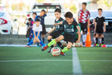 Bangkok, Tayland - 8 Mart 2020: Çocuk futbolculara topları kontrol etmek ve gol kaleye atmak için hızlı koşma konusunda seçici odaklanma. Çocuk futbolcular TC Futbol Kulübü Rama3, Bangkok 'ta topa vurarak birbirleriyle kavga ediyorlar..