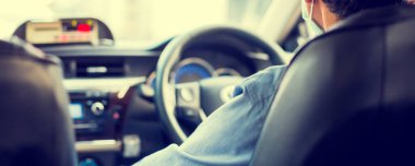 Selective focus of taxi drivers wear masks to protect the corona virus and PM 2.5 dust for drive to serve tourists in Thailand. View from inside the taxi car with blurry service meter.