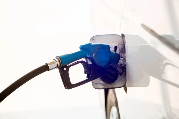 Hand refilling the car with fuel at the gas station on isolated on white background. Oil and gas energy. Refilling the car with fuel at the refuel station. The concept of fuel energy.