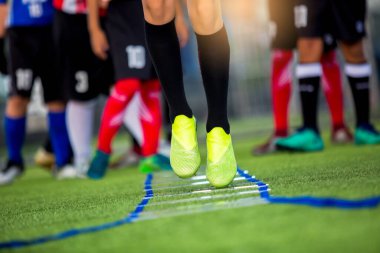Futbolcu koşu ve futbol eğitim için işaretleyici arasında atlamak. Merdiven matkaplar futbol futbol takımı için egzersizler. Genç oyuncu egzersizleri merdiven matkaplar Doğum.