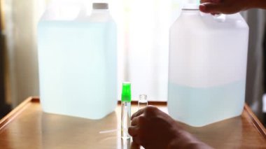 Evde ya da ofiste kullanmak için alkolü cam şişe sprey kapağına dolduruyorsun. Alkol spreyi konseptini kullanarak enfekte olmuş korona virüsünden ve bakterilerden kaçının.. 