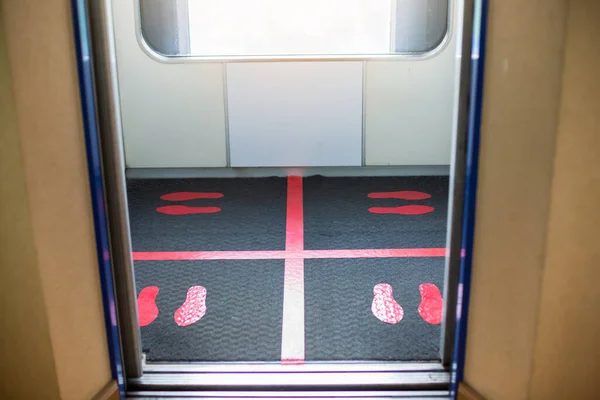Selective focus to floor of passenger lift  with standing marker for social distancing to avoid spreading coronavirus ( Covid-19 ). Location or distance concept. Idea for COVID-19 outbreak.
