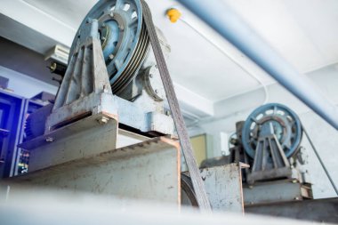 Yolcu kaldırma sisteminin kontrol odasındaki askı kablosuyla hareket eden tekerlek bulanıklığı.