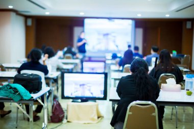 Toplantı odasında toplantı ya da seminer etkinliği için bulanık konuşmacı ve video konferans gözlemcisi olan iş kadınına seçici odaklanma. Onlar beyin işi problemleri ve beyin eğitimi konseptidir..