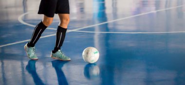 Futsal oyuncu şut ve gol için topu kontrol ediyor. Kapalı spor salonu. Futbolcu, top, futsal sahası.