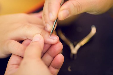 Oğlu için beyaz tırnak törpüsü kullanan seçici anne ellerine odaklan. Anne tırnak törpüsüyle manikür yapıyor ve oğlunu tırnaklarını kesiyor.. 