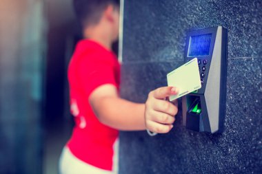 Kapı kontrolü. Çocuk elinde evdeki ya da evdeki kapıyı kilitleyip açmak için bir anahtar kartı tutuyor. Erişim için elektronik kart anahtarı kullanıyor. elektronik anahtar ve parmak tarama erişim kontrol sistemi.