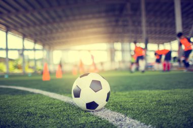 Yeşil suni sahada futbol, bulanık futbol takımı eğitimi. Kalenin önündeki beyaz virajdaki top..